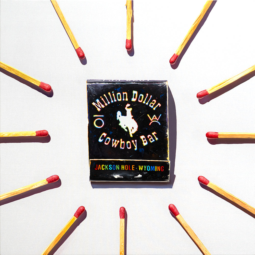 Pop art painting of a black matchbook with cowboy imagery, surrounded by red-tipped matches spelling out Jackson Hole, Wyoming.